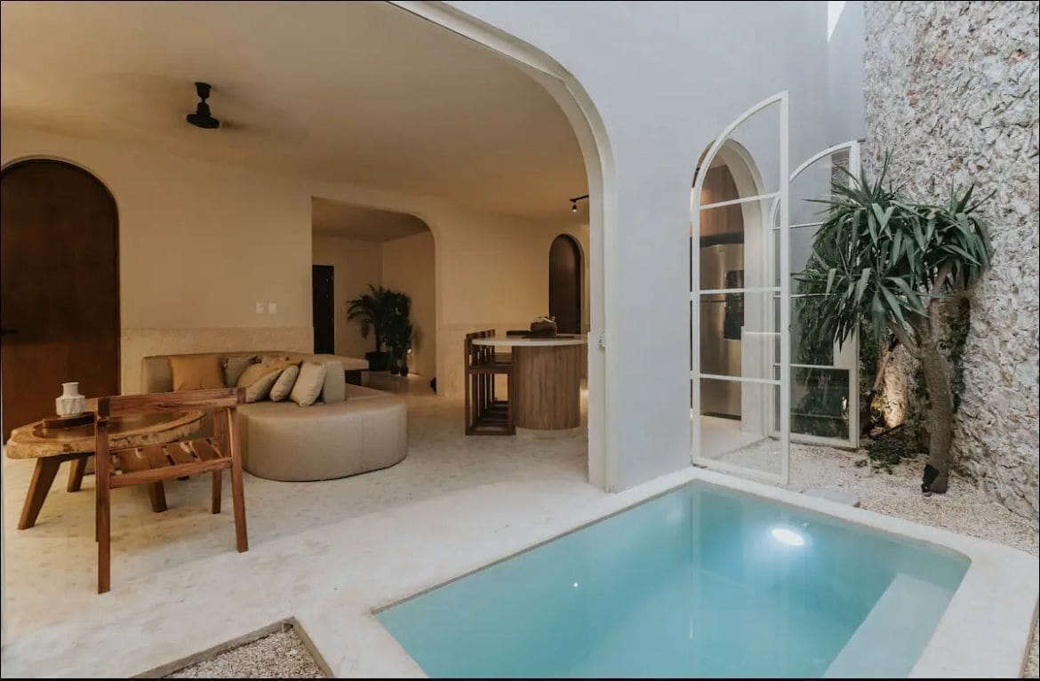 white house with pool and brown kitchen table white art deco doors stone wall and curves archway in merida yucatancolonial house in merida yucatan centro merida homes for sale